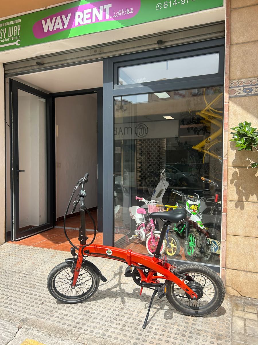 E-bike plegable roja aparcada frente a la tienda